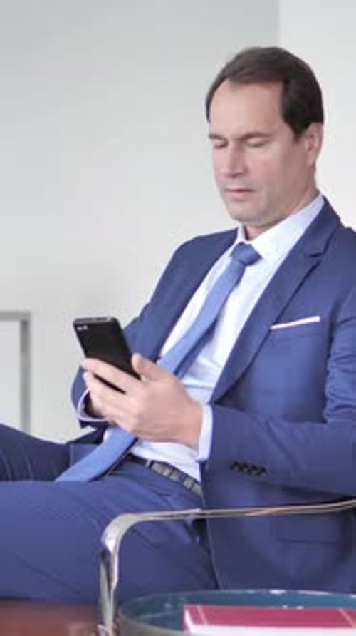 Man in Suit Using Cellphone in Modern Office