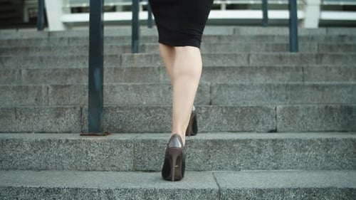 Close Up Unrecognized Woman Legs Going Upstairs At Street. Female Feet Walking In High Heel Shoes...