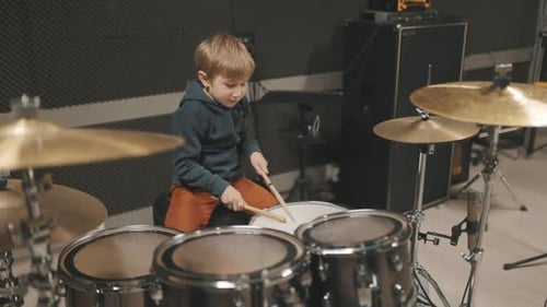 Little Boy Drummer Playing Drums at Music Studio