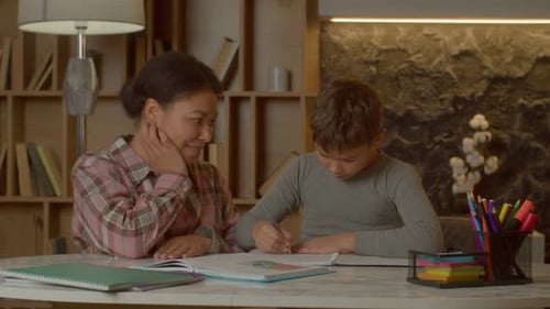 Loving Pretty African American Mom and Cute School Age Son Bonding at Home