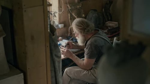 Artesano sénior soldando en taller