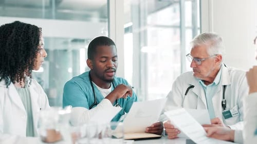 Doctors Meeting at Conference Table Discussing Medical Records