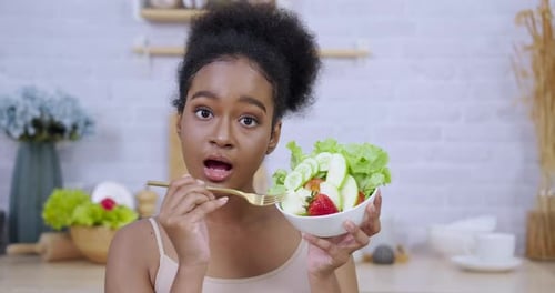 Woman Holds Bowl of Salad in Kitchen