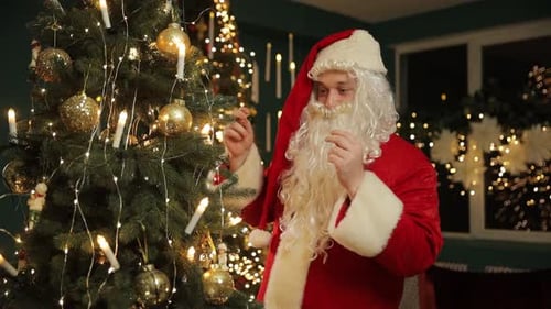 Man dressed as Santa Claus decorates Christmas tree