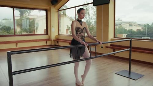 Female Ballerina Stretching at Dance Barre Indoors