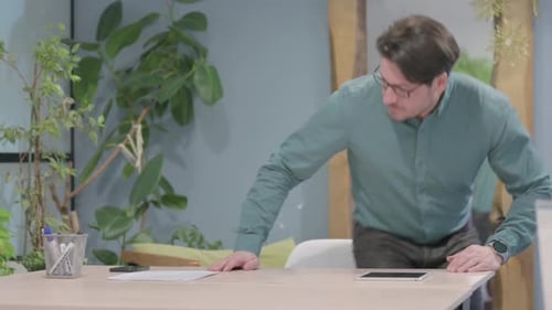 Hombre de mediana edad que regresa al escritorio de la oficina