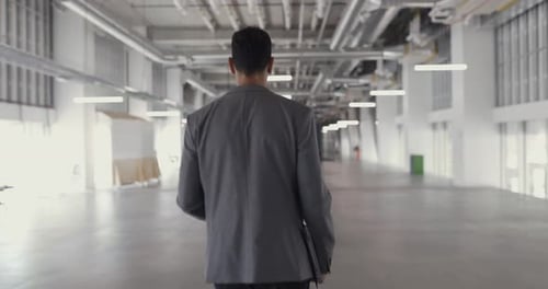 Empresário andando pelo espaço vazio de um escritório moderno em tempo real