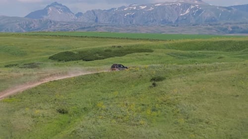 Black Suv Driving on Dirt Road in Scenic Mountain Valley