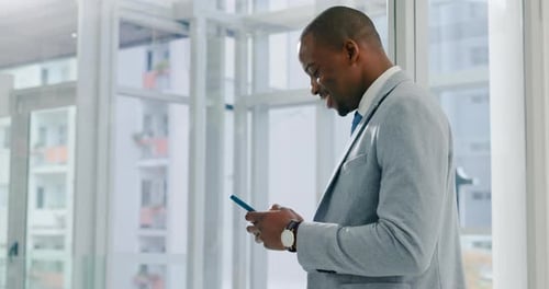 Smiling Businessman Using Cell Phone in Modern Office
