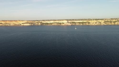 Aerial View of a Luxury Sailing Ship with White Sails in the Sea in the Evening Sunlight Luxurious