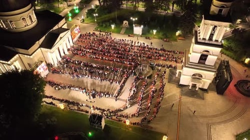 Une foule de personnes se rassemble sur la place devant la cathédrale de Central Park, à Chisinau, la nuit