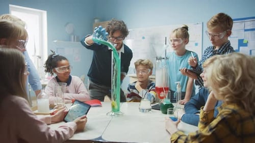 Elementary School Science / Chemistry Classroom: Teacher Shows Chemical Reaction Experiment to Grou