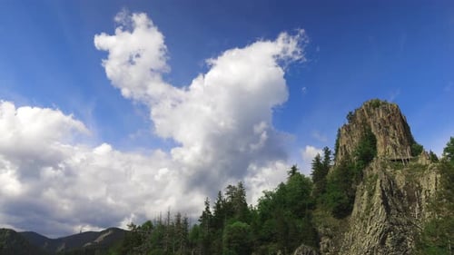 Felsgipfel eines der Rhodopen mit einem Hang mit einem Fichtenwald im Hintergrund