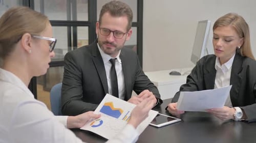 Team Discusses Financial Data in Modern Office