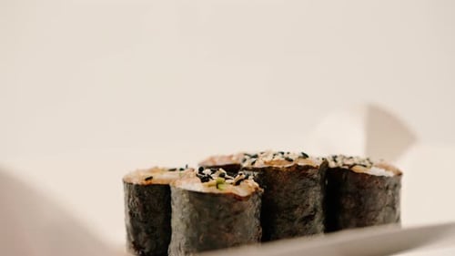 Close-up of maki roll with avocado with soy sauce in sushi delivery box on white background