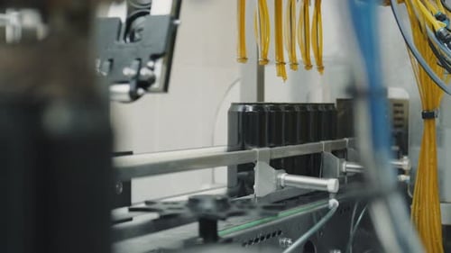 Black Cans Moving Along Conveyor Belt in Factory