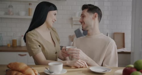 Young Couple Talking Over Coffee in Kitchen