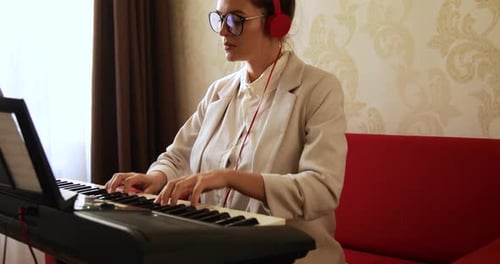 Woman Plays Piano with Red Headphones