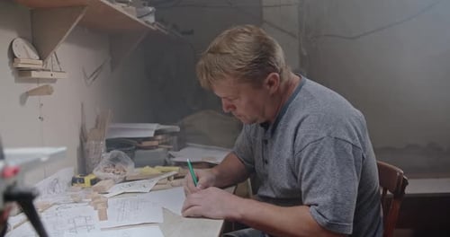 Man Drawing at Table Indoors