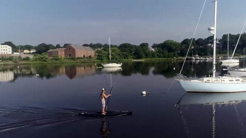 Paddleboarder paddling away in a harbor.