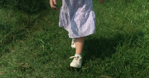Girl Walking Through Grass Field