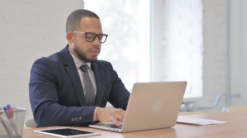 Professional Man Massages Sore Neck at Desk