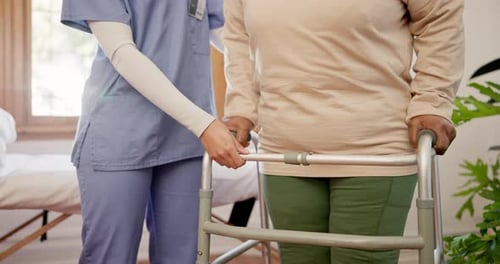 Nurse Assists Senior Woman Using Walker Indoors
