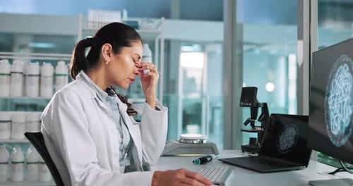 Female Scientist Looking Stressed at Computer in Lab
