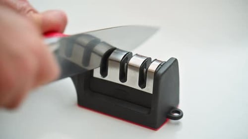 A woman sharpening kitchen knives