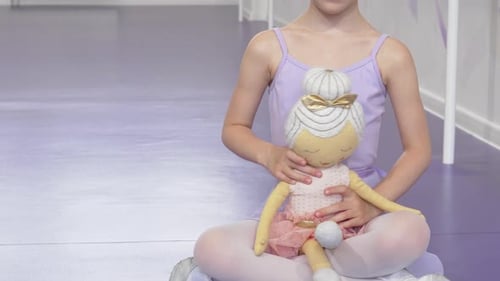 Joyful Little Ballerina Girl Beaming While Holding Her Beloved Ballerina Doll