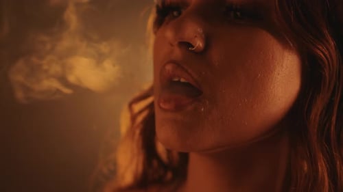 Woman Exhaling Cloud of Smoke Close Up