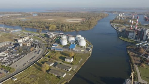 Aerial view of a large oil terminal with storage tanks by a river