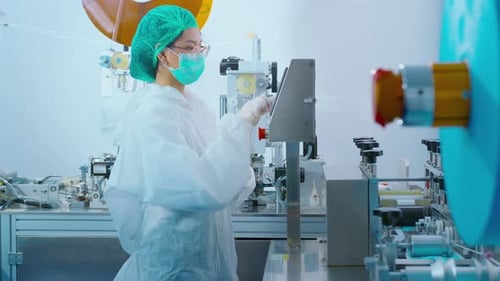 Arbeiter, die in einer modernen Fabrik chirurgische Masken herstellen