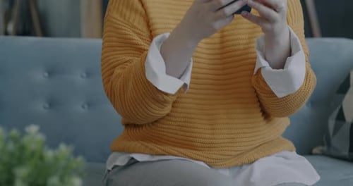 Happy Young Woman Taking Smartphone and Looking at Screen Smiling Enjoying Online Communication at