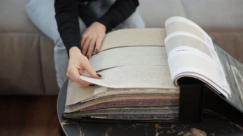 Woman Browsing Fabric Swatches Interior Design Sample Book