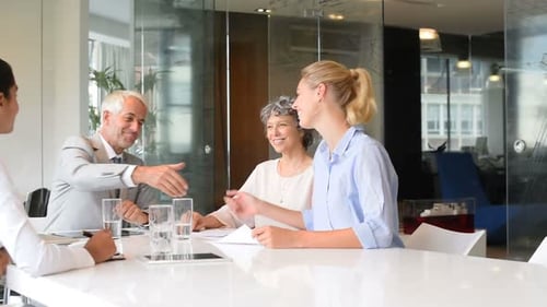 Businesswoman and senior manager handshake seals deal in modern office in slow motion