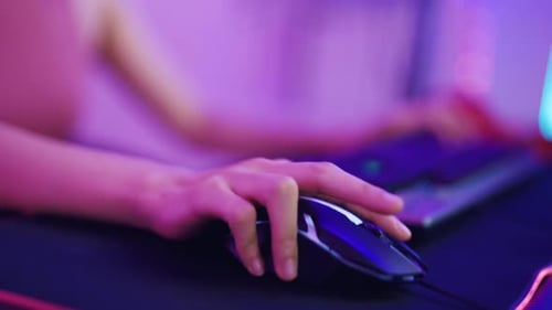Mano cercana de una bella joven asiática jugando en la computadora.