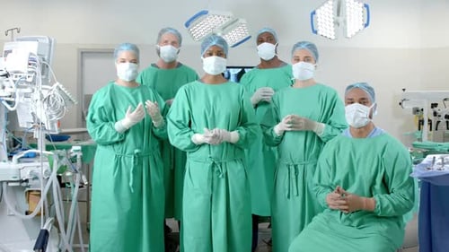 Portrait of diverse surgeons wearing surgical gowns in operating theatre, slow motion
