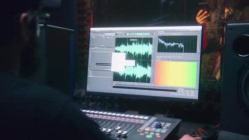 Sound Engineer Uses Control Mixing Surface and Computer