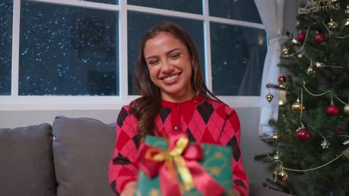 Cheerful Woman Presents Christmas Gift at Home