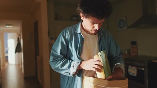 Man Unpacking Groceries in His Kitchen