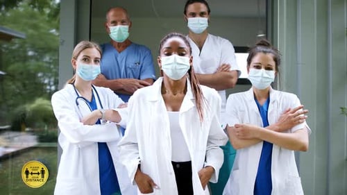 Team of doctors in scrubs and white coats