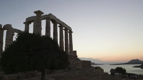 Photo panoramique de personnes admirant le coucher de soleil au temple d'Athéna Sounia
