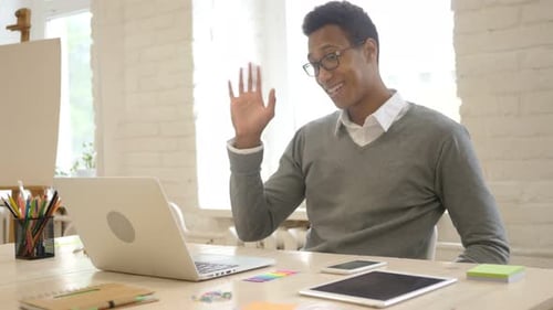 African Man Doing Online Video Chat in Office