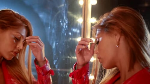 Woman Looks at Self in Mirror at Night