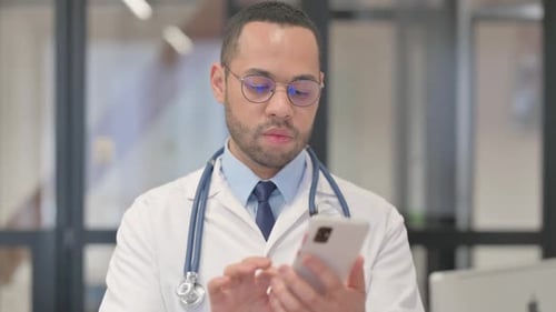 Medical Professional Using Smartphone in Modern Hospital Office