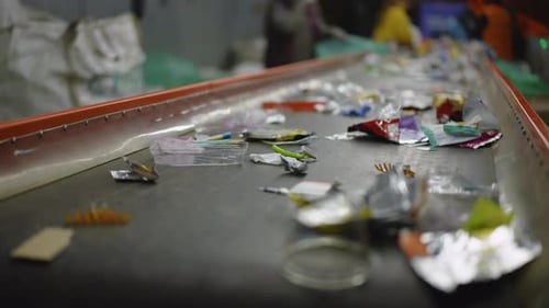 Trash Moving Along Conveyor Belt at Recycling Plant