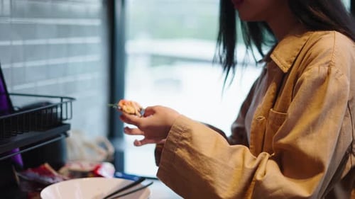 Woman Eats Small Appetizing Bite in Kitchen
