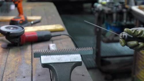 Trabajador manual que trabaja en una fábrica de metal con herramientas manuales