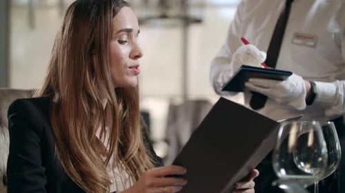 Business Woman Ordering Food From Restaurant Menu. Waiter Taking Order From Businesswoman